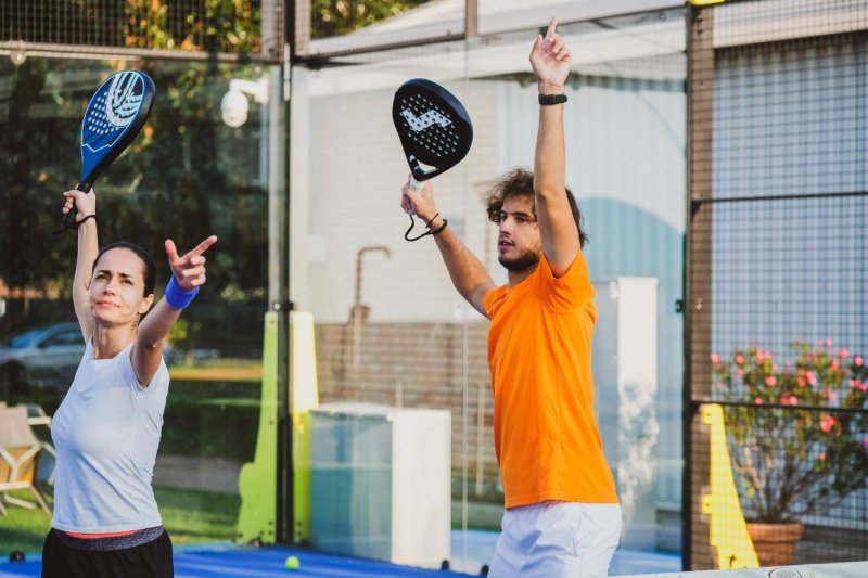man and woman practicing padel movements