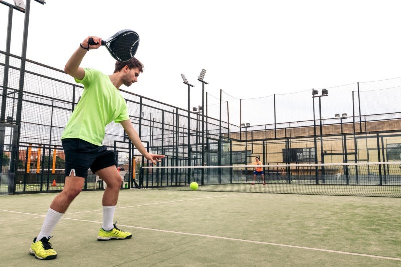 man hitting padel ball on court