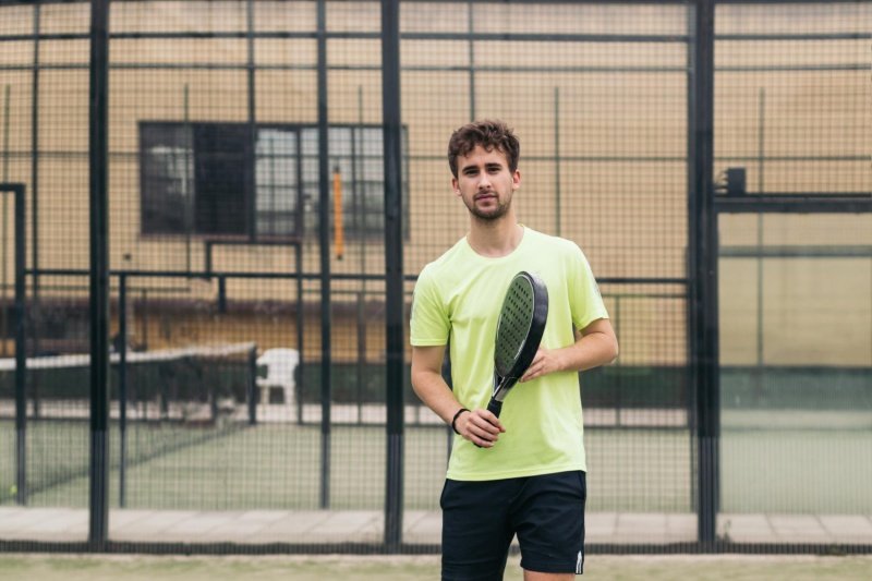 man holding padel racket on court