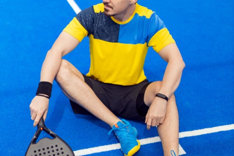 man resting on padel court with racket