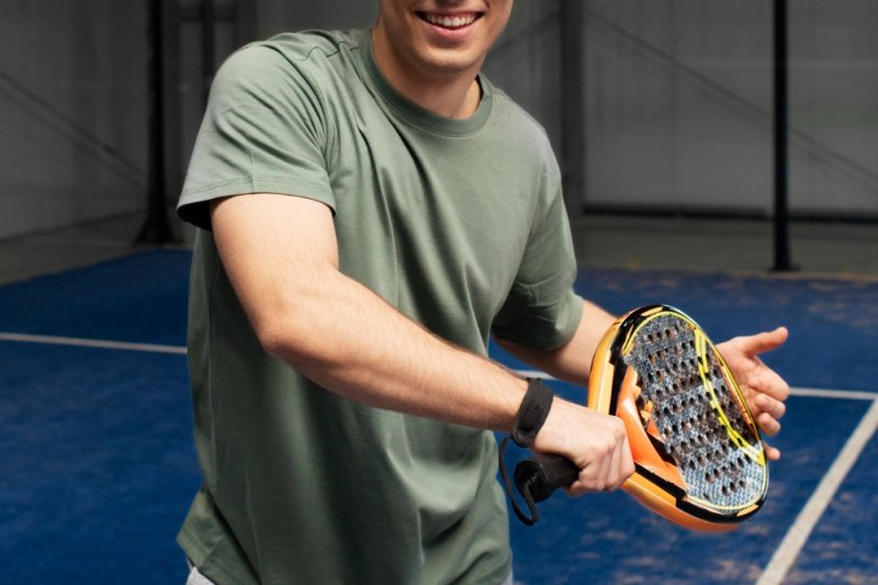 padel-player-smile-racket man smiling and holding padel racket