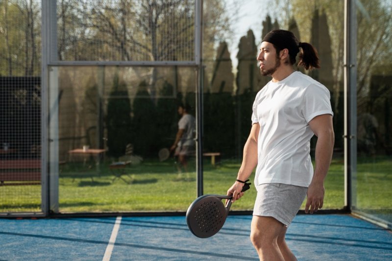 man walking on padel court with racket