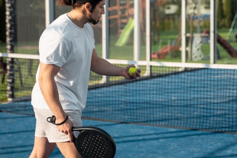 padel-serve-action-court man holding padel racket and ball preparing to serve