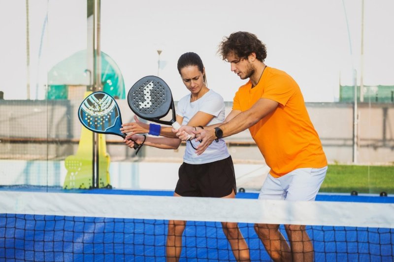 man and woman practicing padel at net