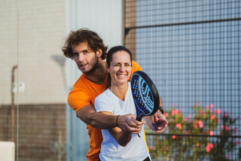 man and woman practicing padel swing together