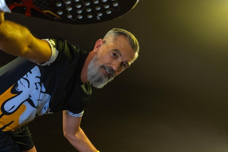 Confident padel athlete Senior padel player posing with a racket