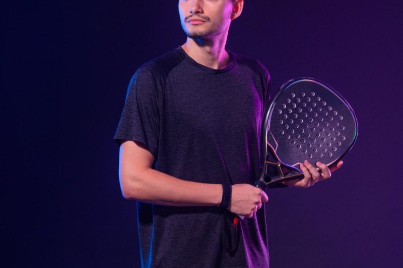 Focused Padel Athlete Male padel player in dark shirt holding racket with focused expression
