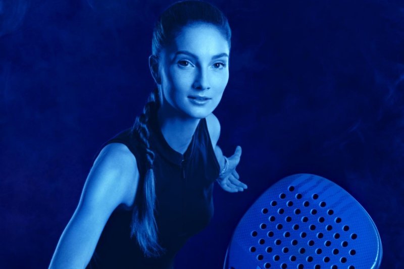 Focused female padel player Female padel player in action with a racket