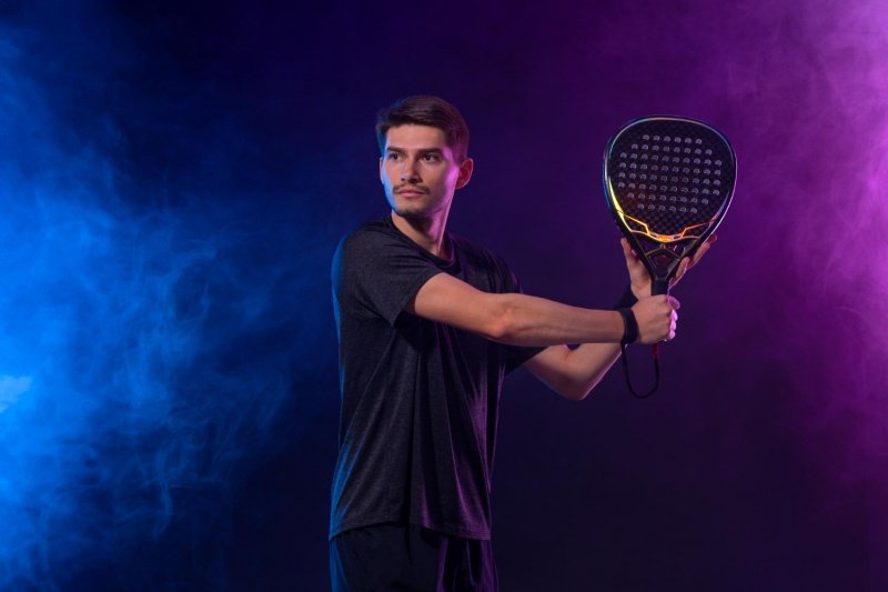 Focused padel athlete Padel player preparing for a shot under dramatic lighting
