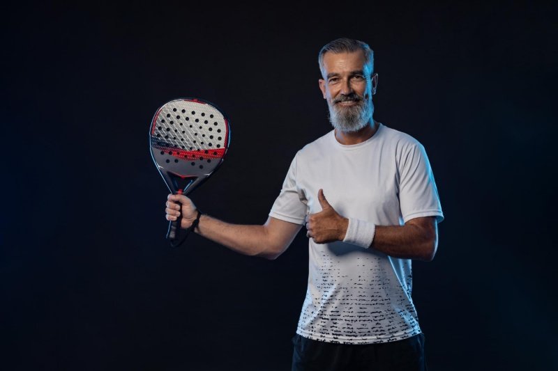 Happy padel player Smiling padel player holding racket and giving thumbs up
