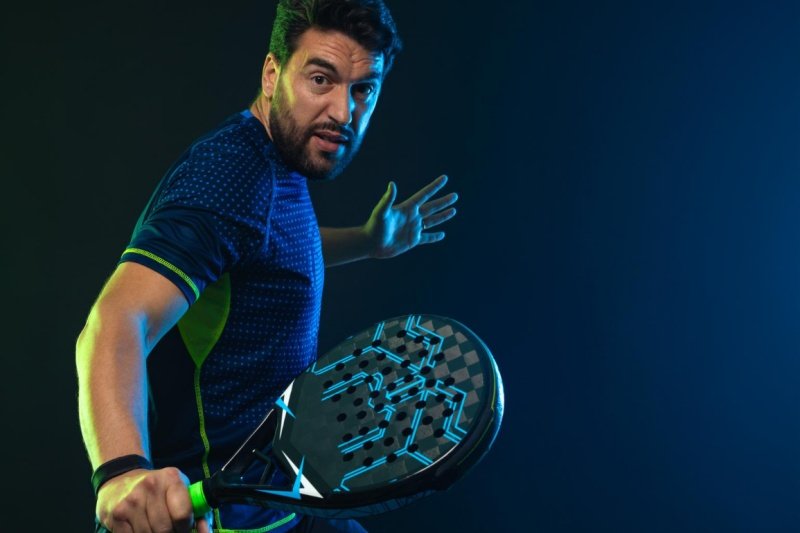 Focused padel player with black carbon racket