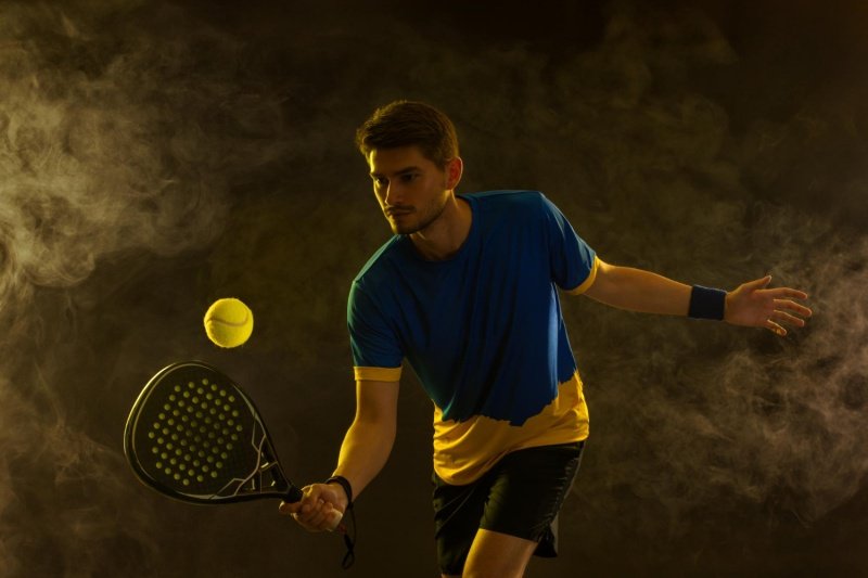 Intense padel moment Padel player focusing on a shot under dramatic lighting