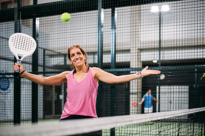 Joyful woman playing padel Happy female padel player celebrating on the court