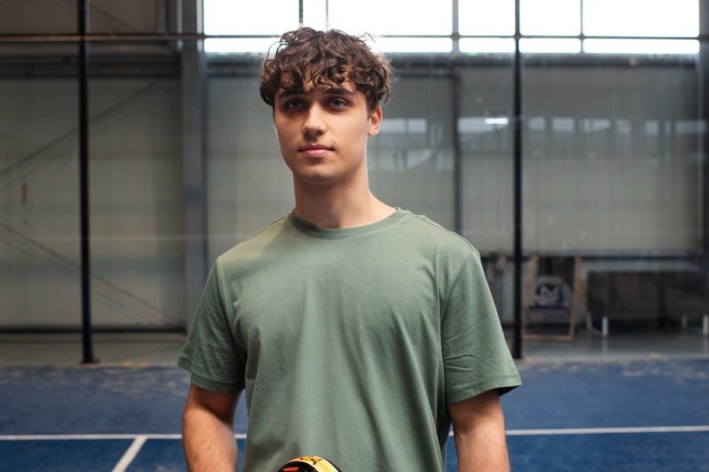 Young padel player standing on court