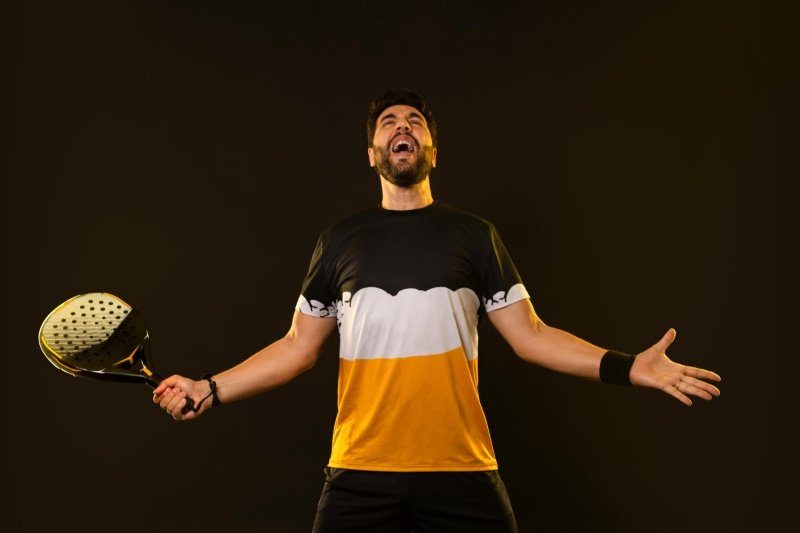 Padel Player Celebration Male padel player celebrating with racket in hand