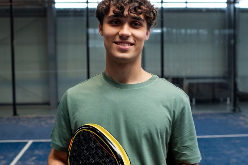Smiling padel player holding carbon racket