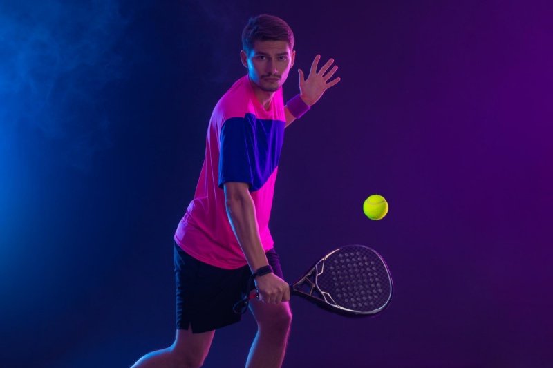 Padel backhand action Padel player executing backhand shot, focused with dynamic lighting