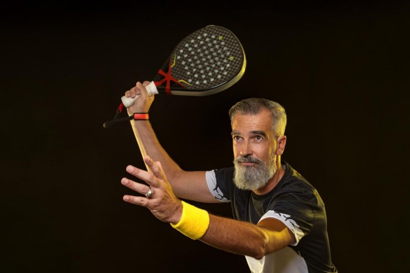 Padel player in action Senior padel player preparing for a powerful shot
