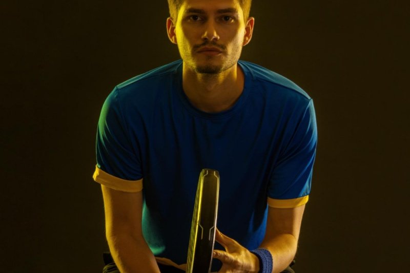 Padel player ready stance Focused padel player holding a racket in a ready position