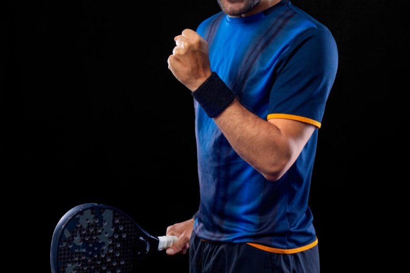 Padel player victory pose Padel player celebrating with clenched fist and racket