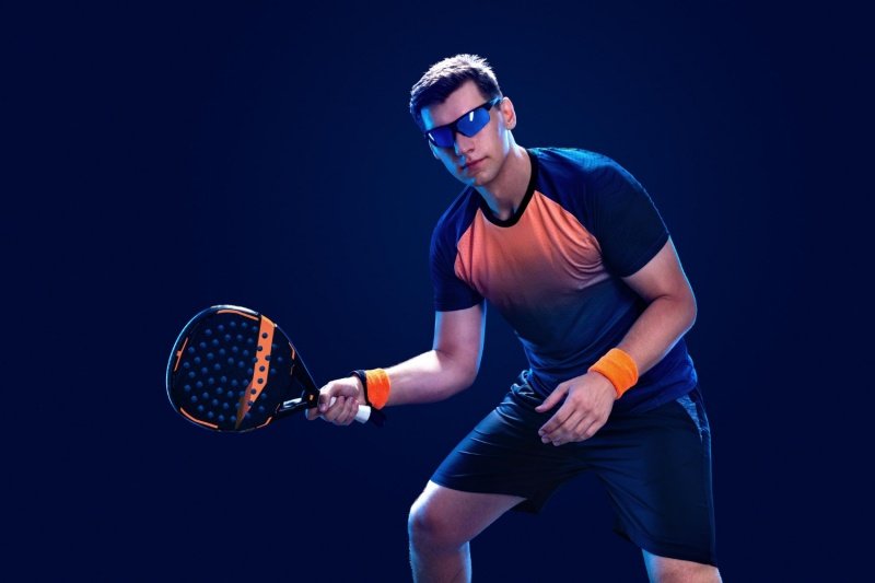 Stylish padel athlete in action Padel player in sporty sunglasses ready to play