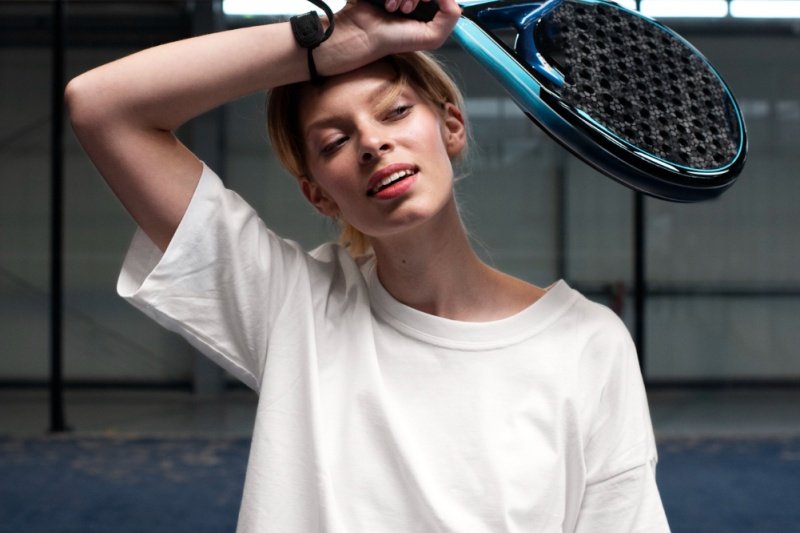 Female padel player resting with racket on forehead after a game