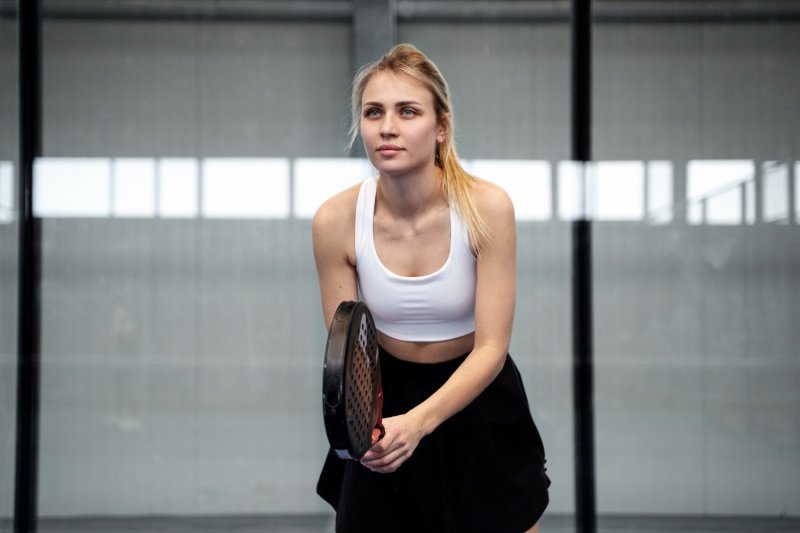 Focused Padel Player Female padel player in ready stance on indoor court