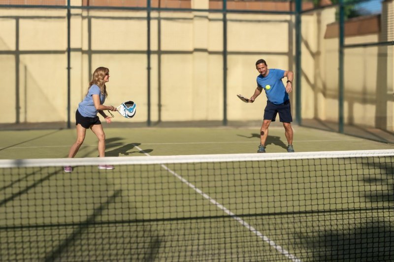 Outdoor Padel Rally Two padel players rallying on sunlit outdoor court