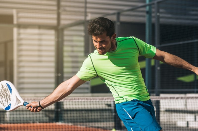 Padel Forehand Focus Focused padel player hitting forehand shot outdoors