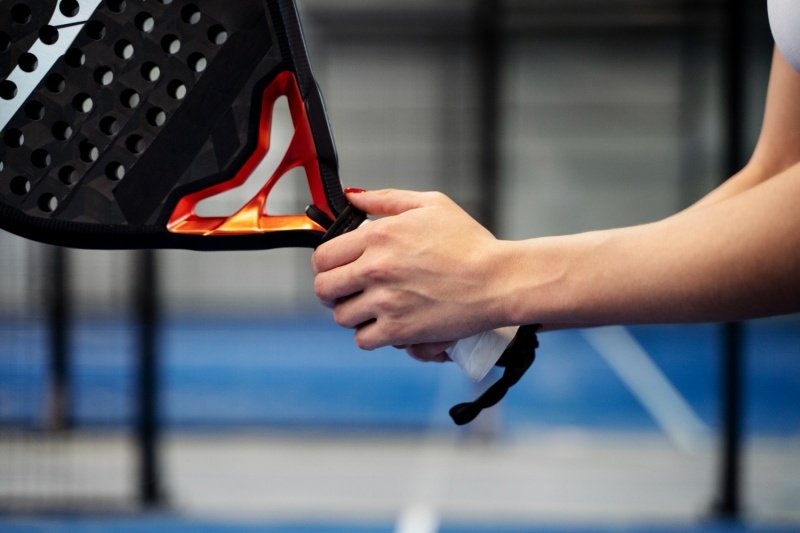 Padel Racket Grip Detail Close-up of female player gripping modern padel racket