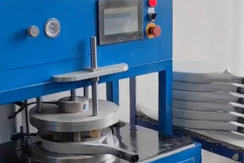 Padel Racket Molding blue molding machine for shaping padel rackets with finished frames stacked nearby