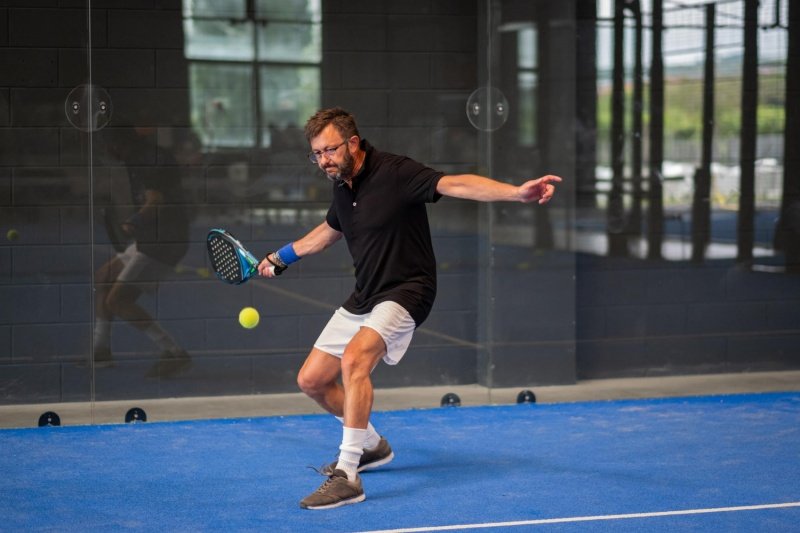 Padel Backhand Practice Padel player executes backhand shot during indoor practice session