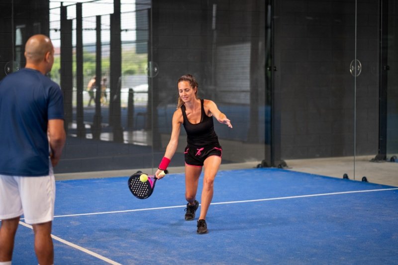 Padel Low Return Drill Female player focuses on returning a low shot in padel practice
