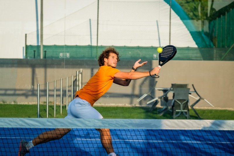 Padel Net Volley Male padel player stretches forward for a volley near the net