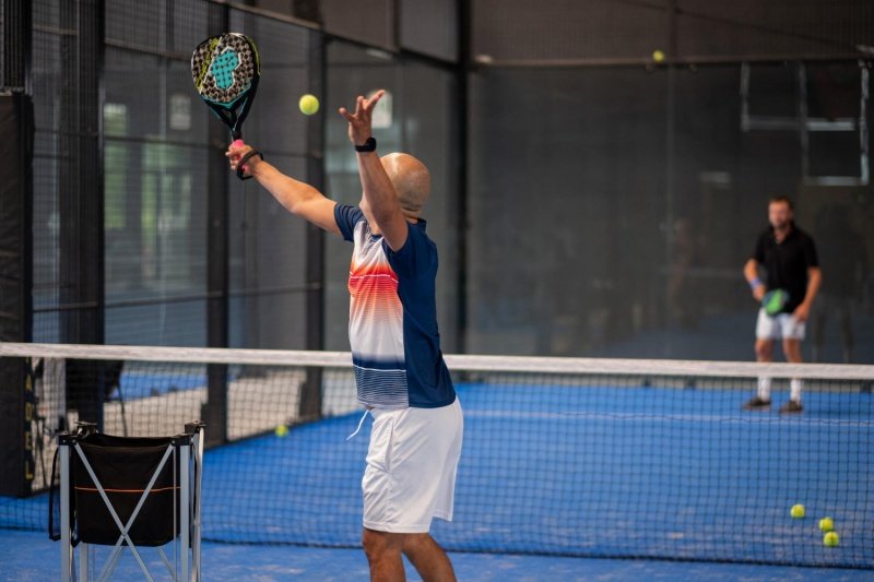 Padel Serve Drill Padel player serves ball during indoor training session
