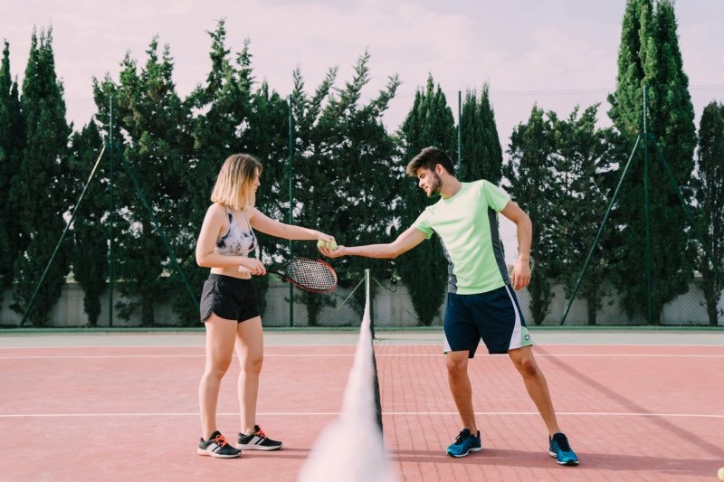 Padel Sportsmanship Two players shake hands over net on outdoor court