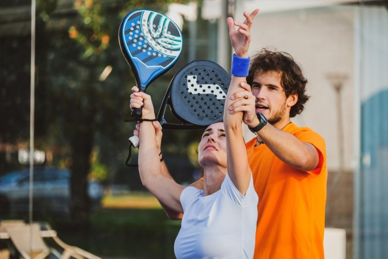 Padel Technique Training Padel coach helping woman with overhead stroke technique