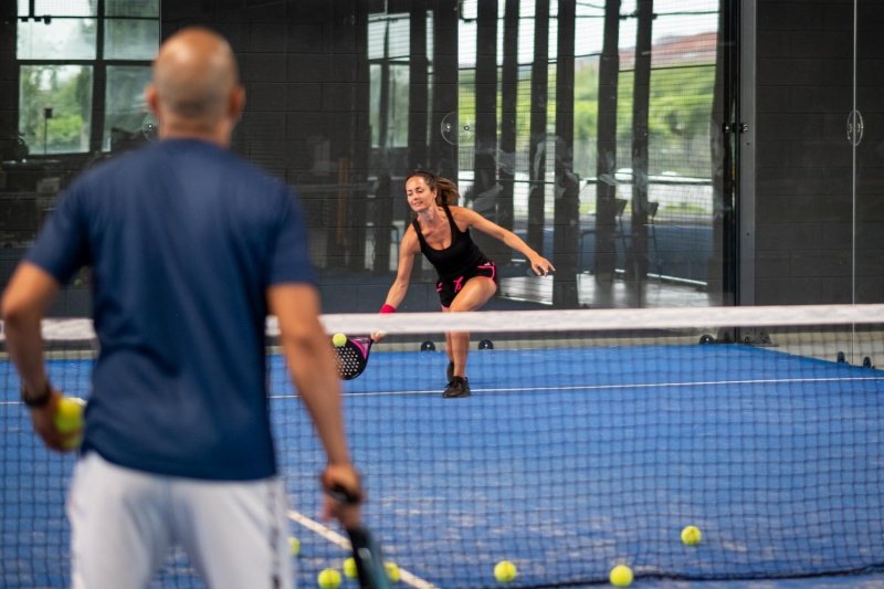 Padel Training Drill Woman practices low padel shot during training session